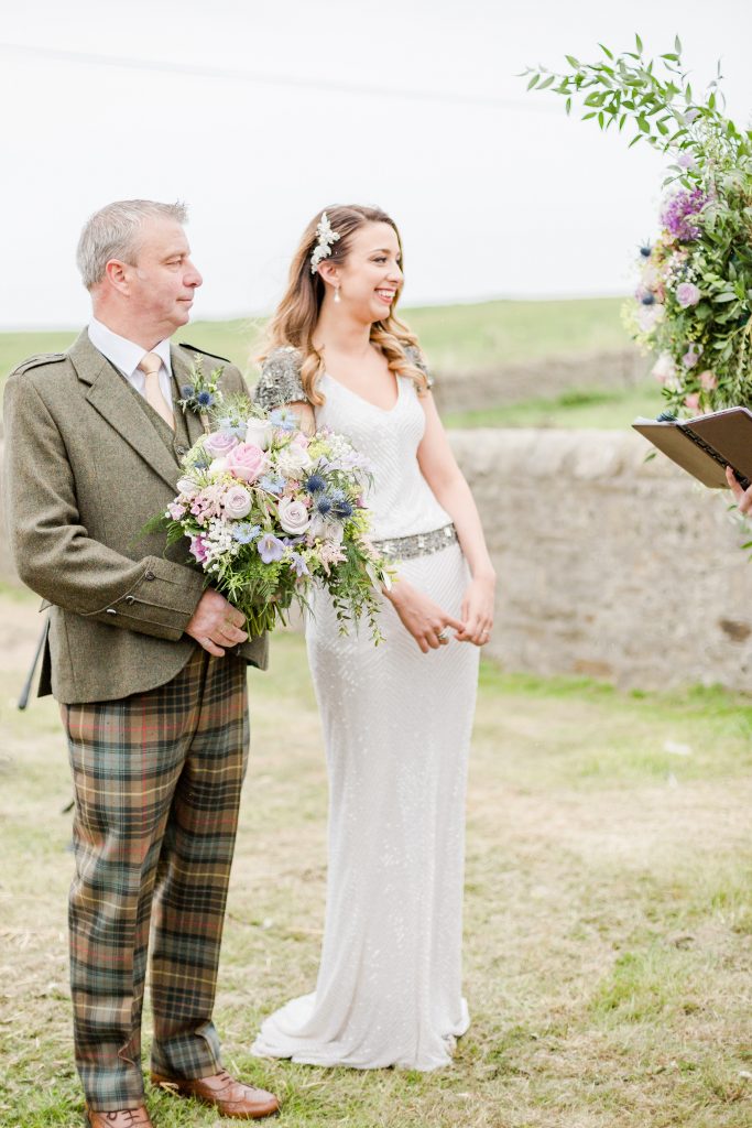 bride and father of bride smiling at celebrant