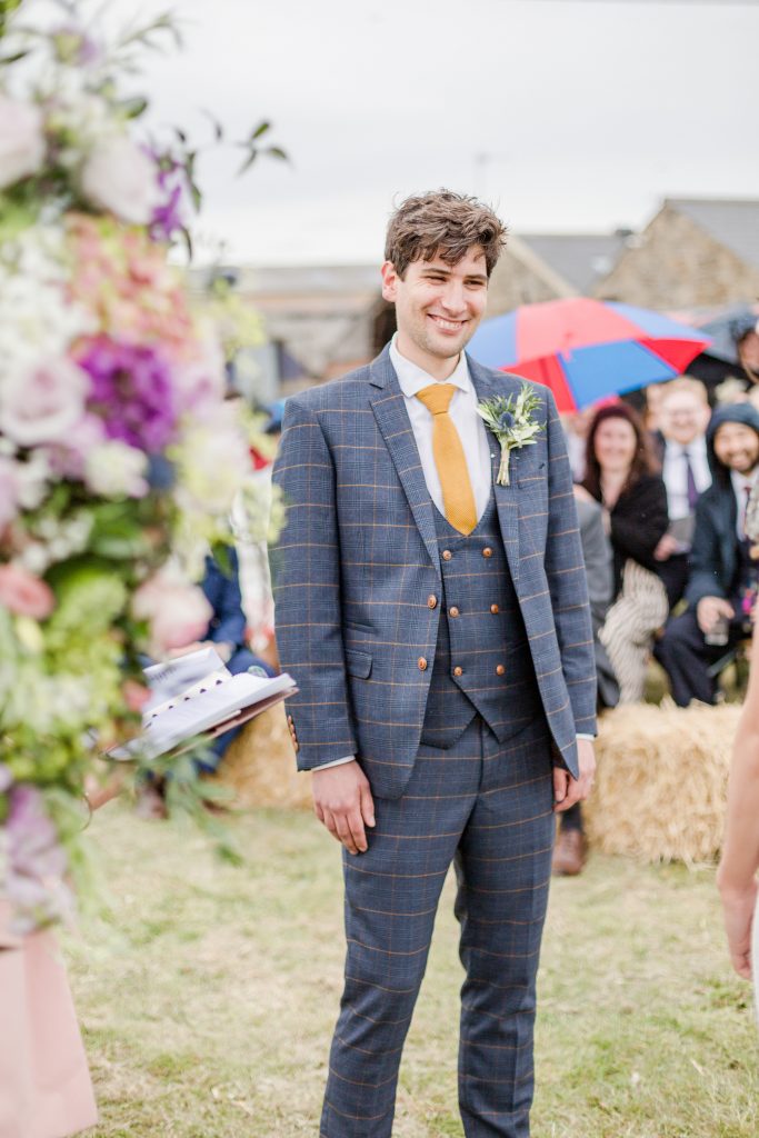 groom smiling at camera guest in background