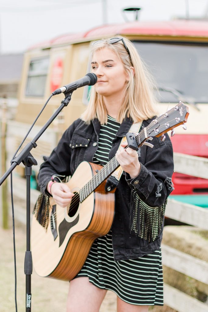 singer playing guitar at festival style wedding