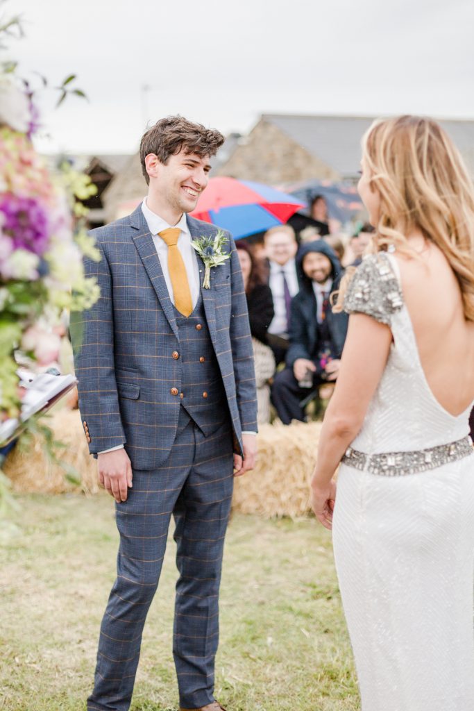 groom smiling at bride at alter