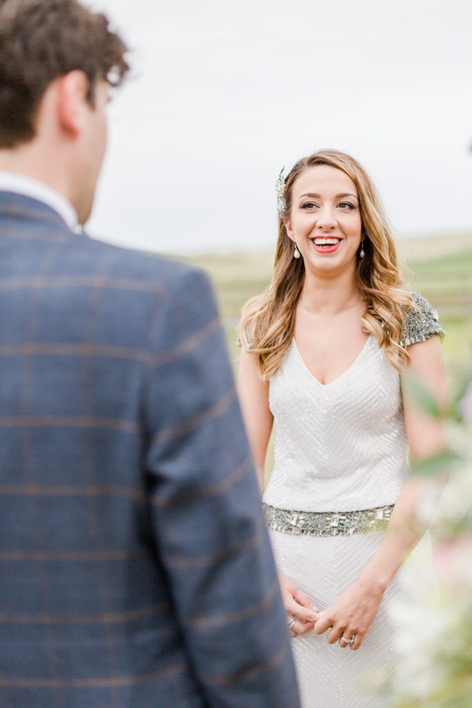 bride smiling at groom at outside alter