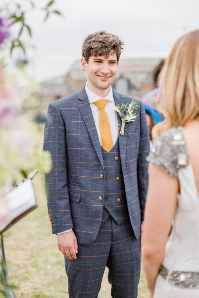 groom smiling at bride at outside wedding ceremony