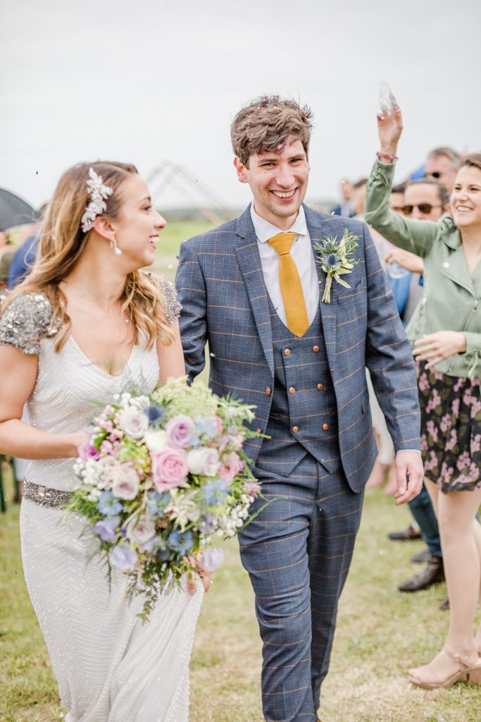 bride and groom smiling as they exit outdoor ceremony