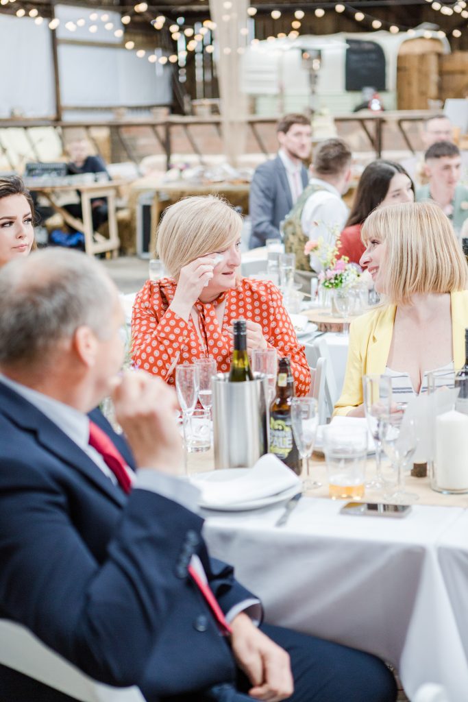 wedding guest drying eyes after barn wedding speeches