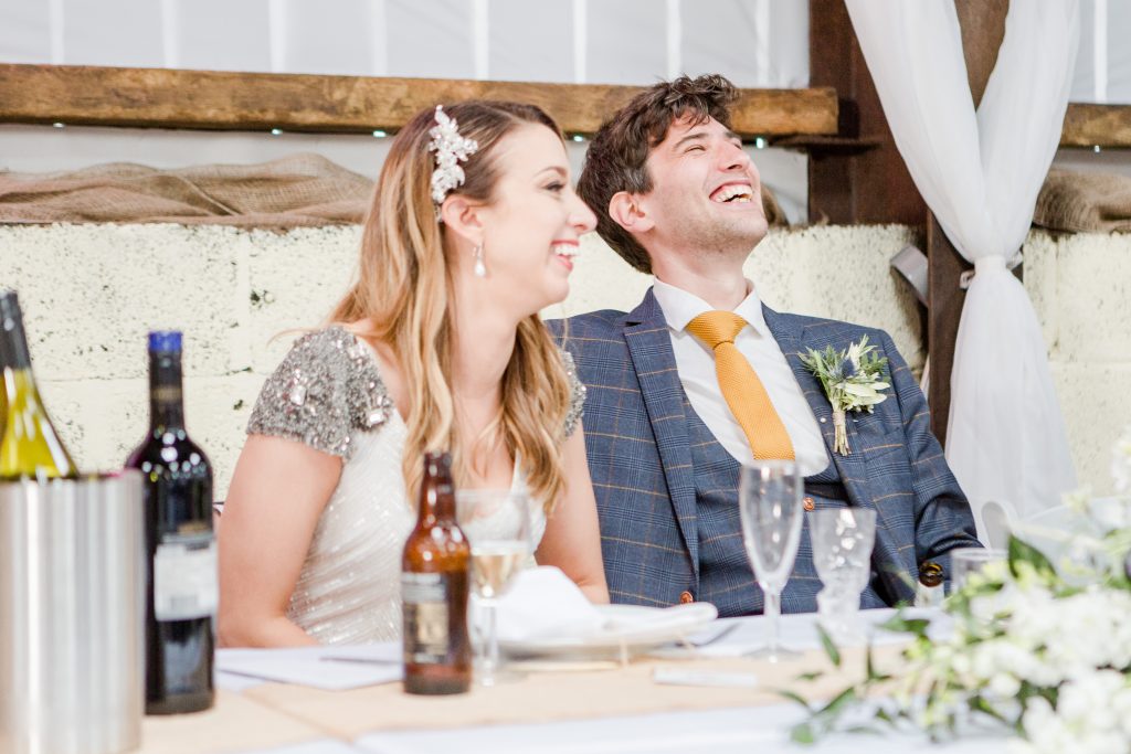 bride and groom sat at top table laughing