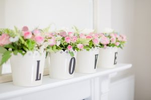 Pink roses in four flower pots spelling LOVE