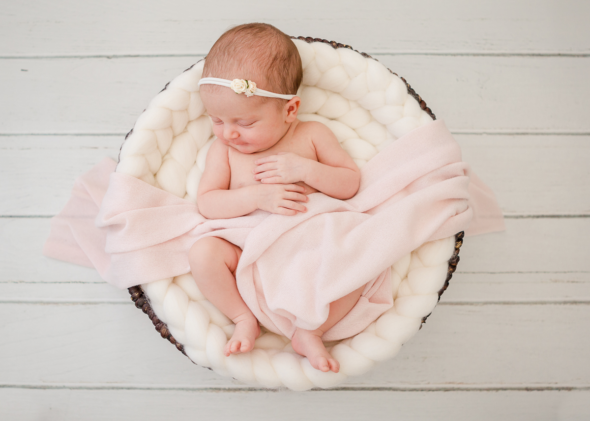 newborn asleep in round basket