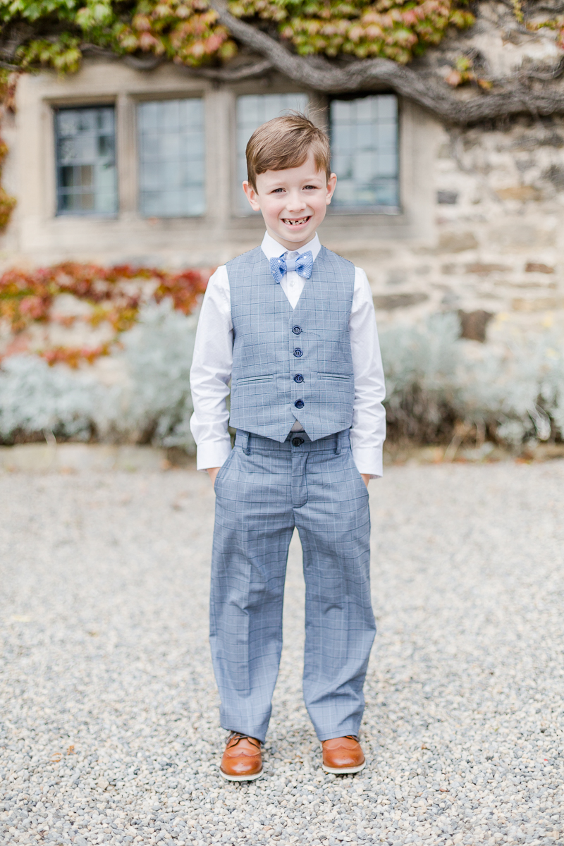 page boy in suit trouser waistcoat with hands in pockets