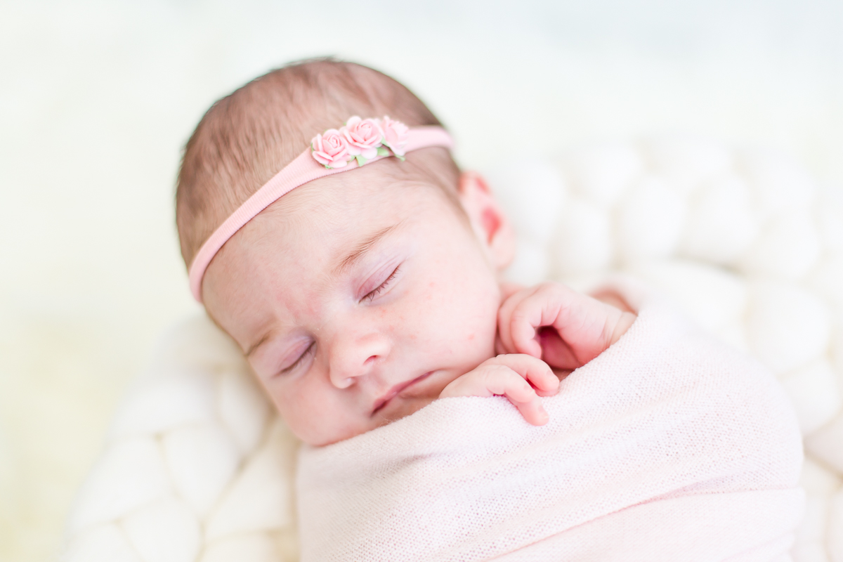 baby girl wrapped in pink asleep with pink head band