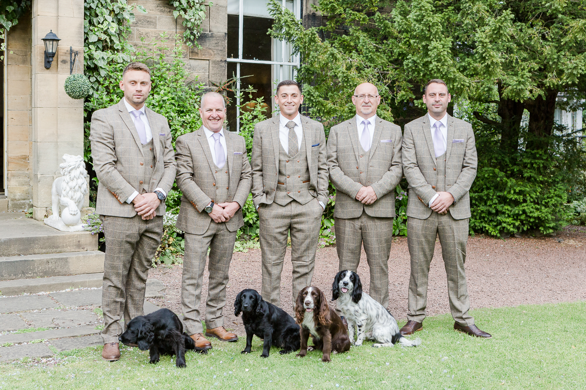 grooms men dressed in tweed posting with four dogs