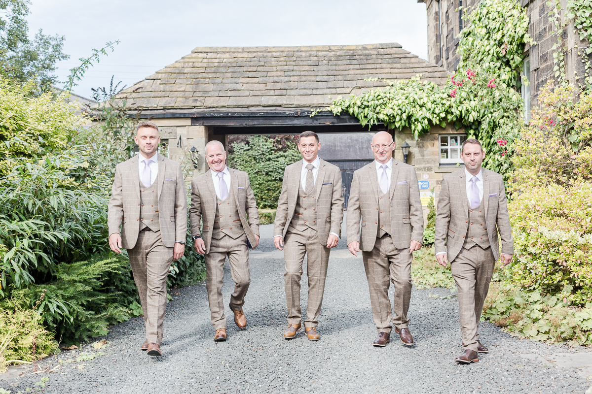 groomsmen walking towards camera on drive way