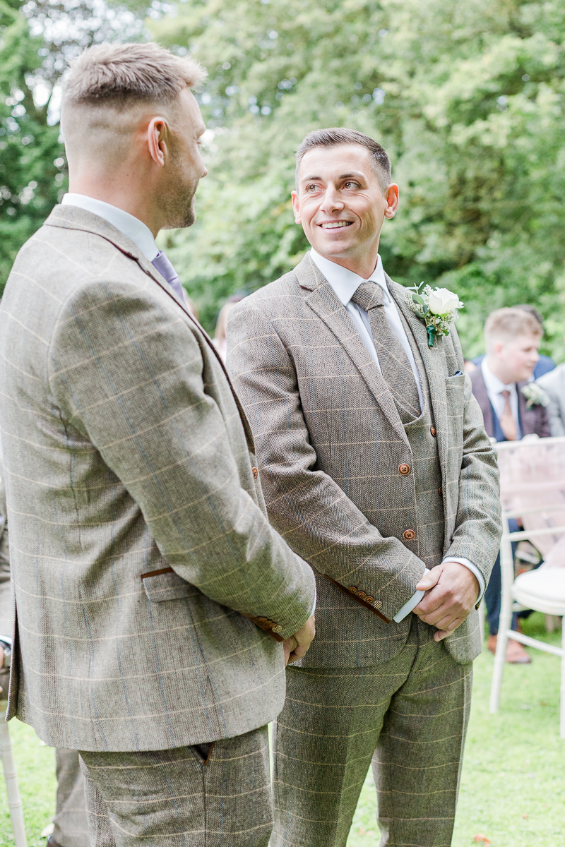 groom waiting at alter with best man smiling