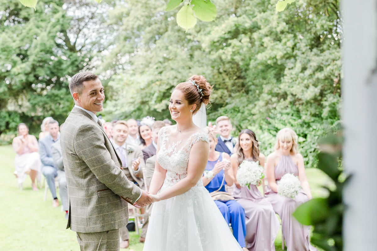 bride and groom laughing at alter