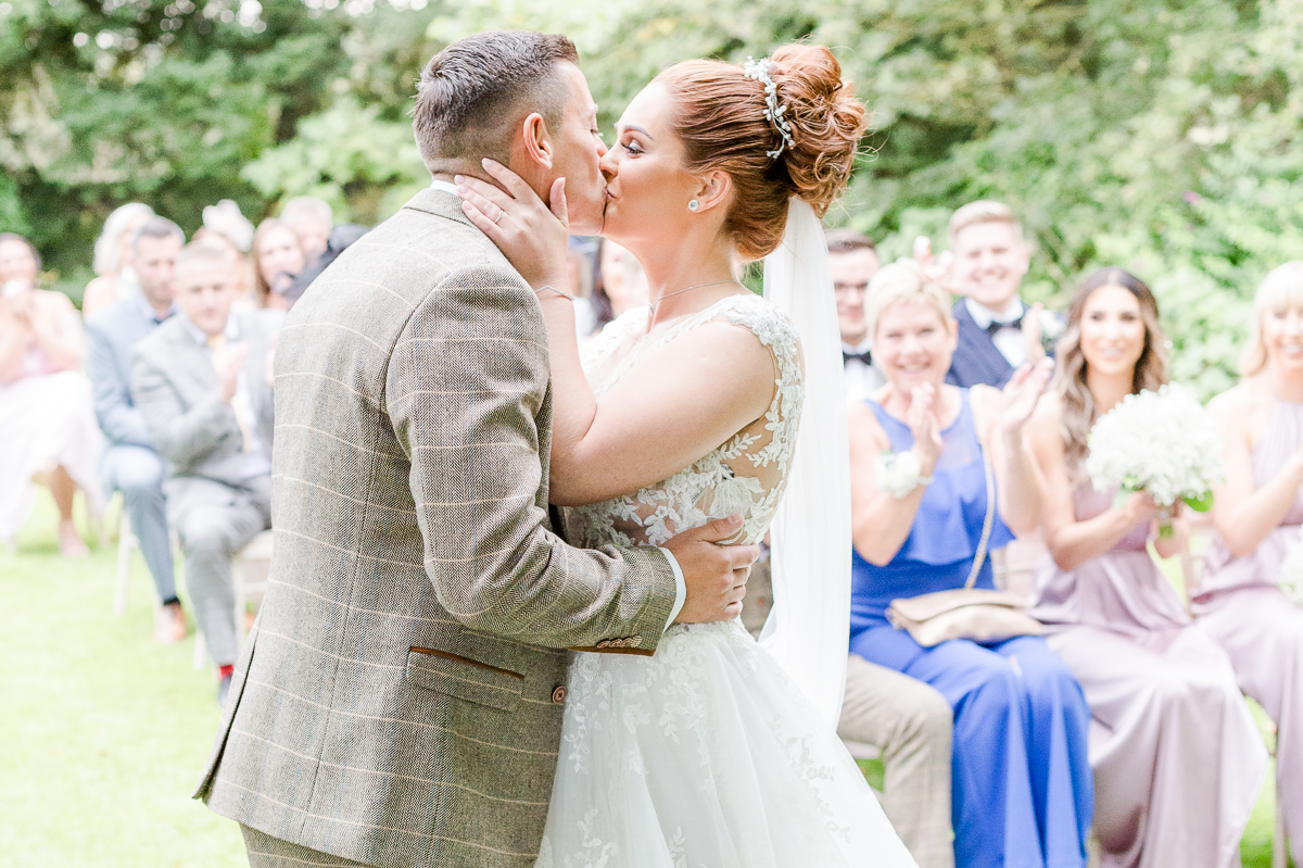 bride and groom kissing at alter