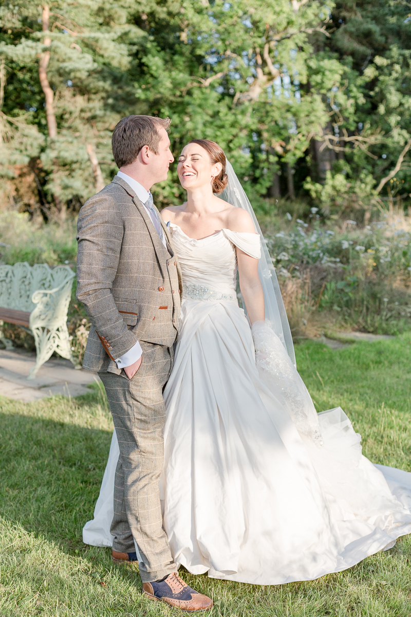 bride and groom in garden smiling at each other