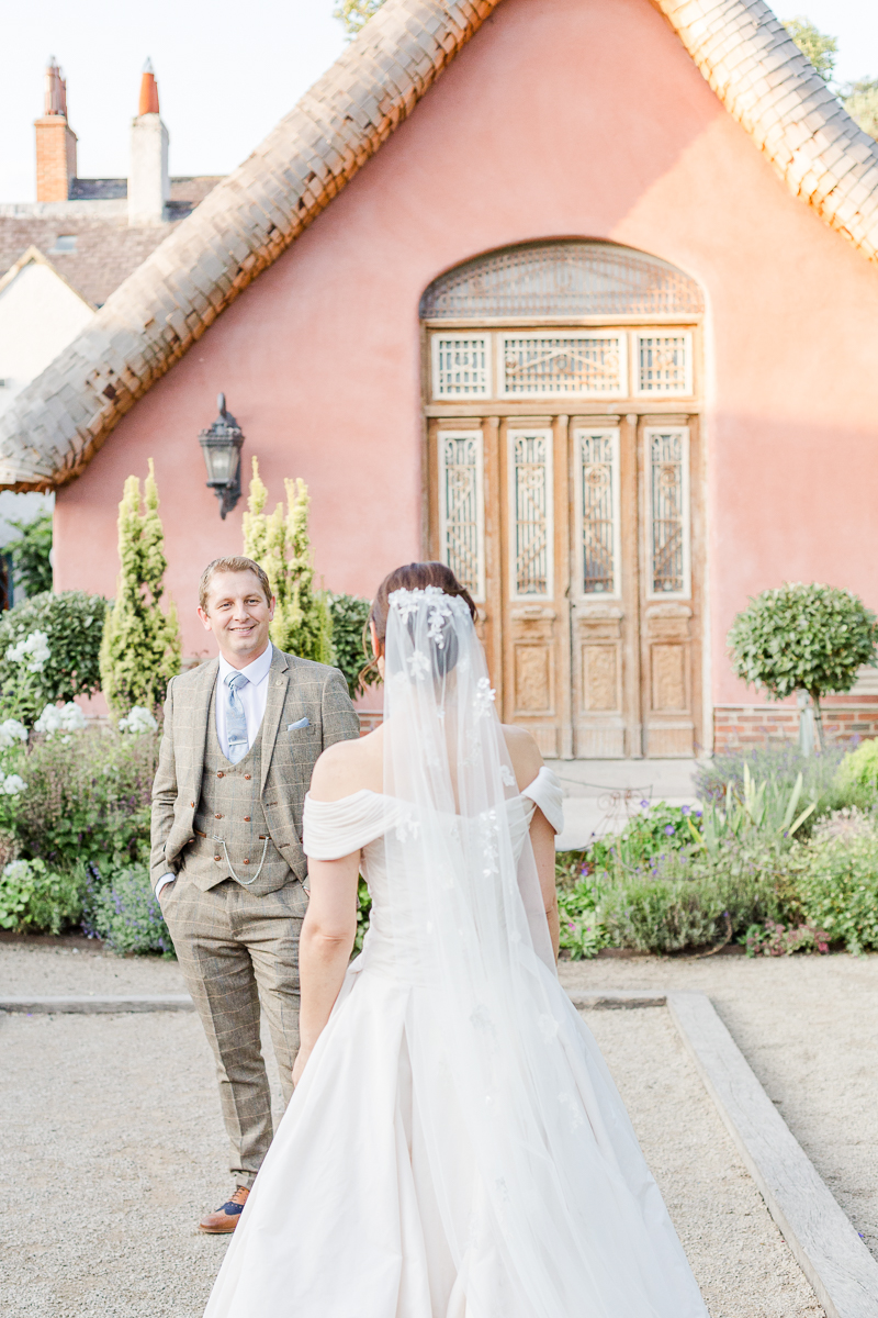 groom looking at bride in front of le petit chateau