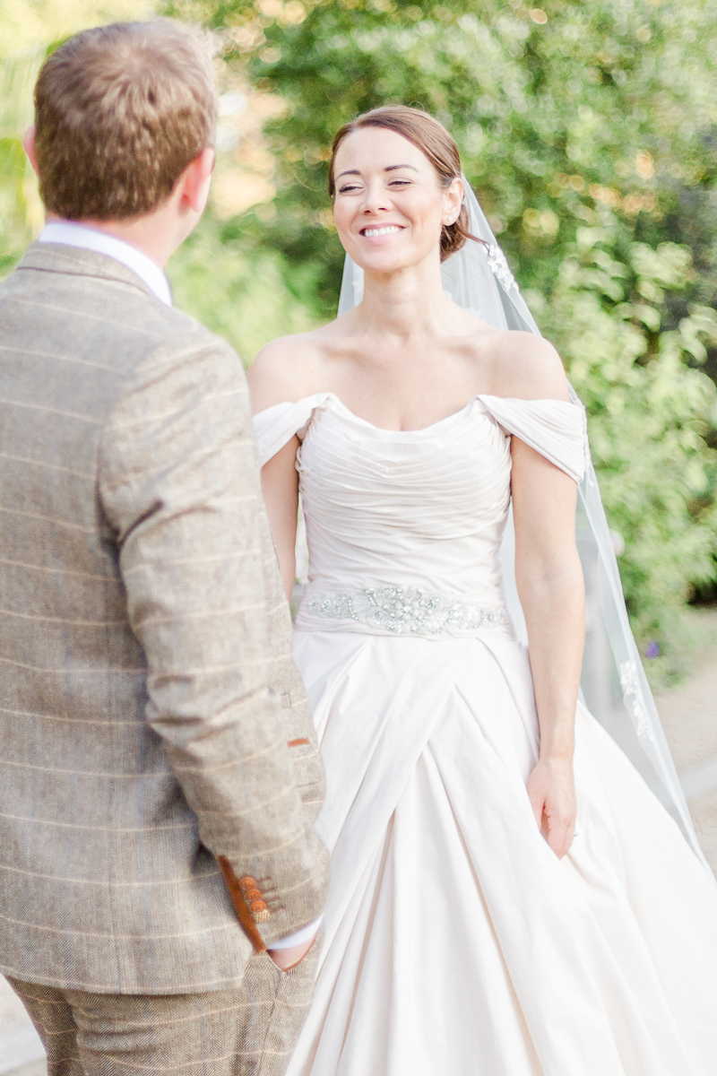 grooms back bride smiling towards camera looking at groom