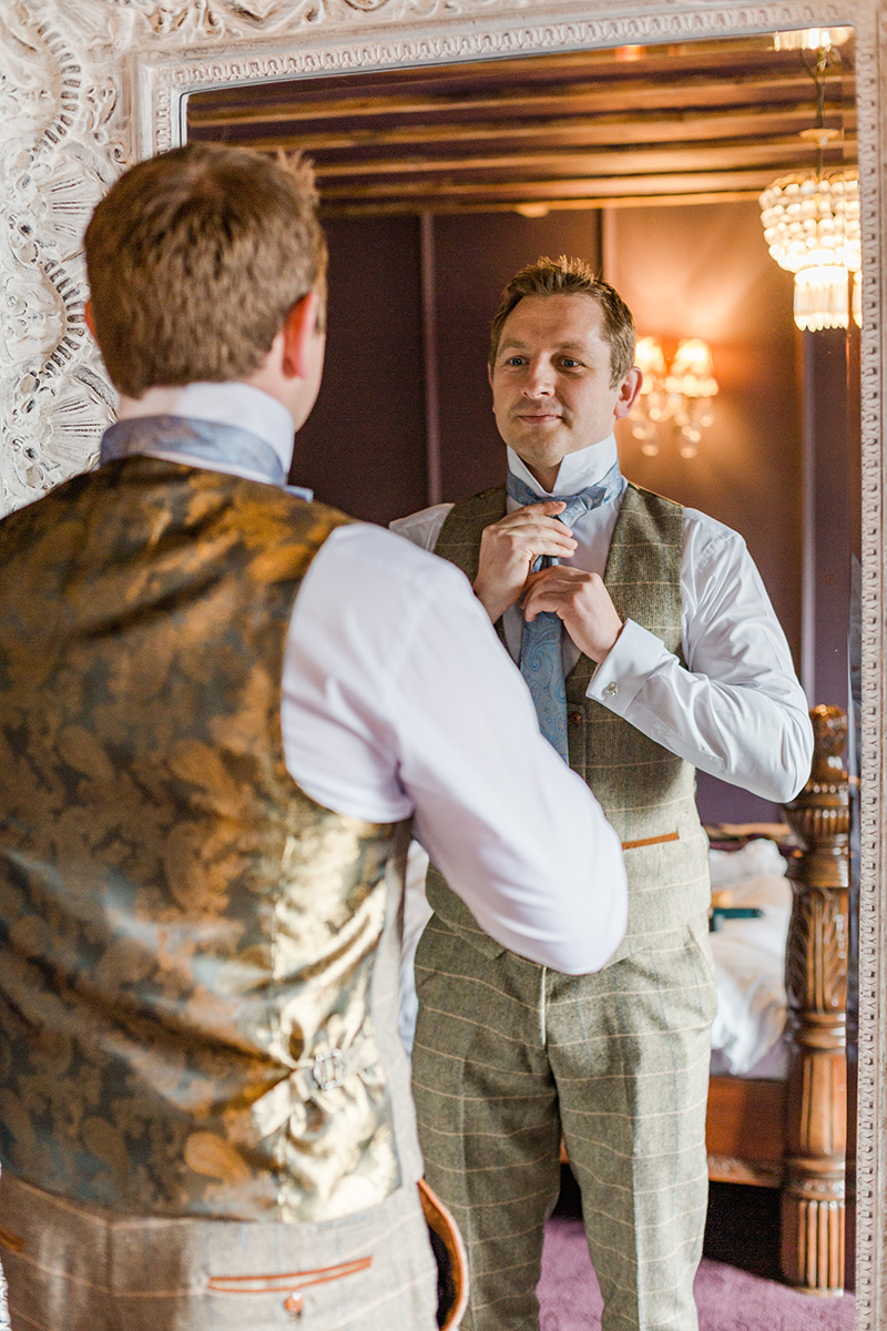 groom doing tie in mirror