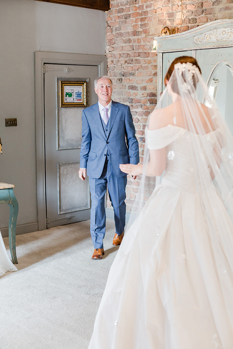 father of bride smiling emotionally at daughter