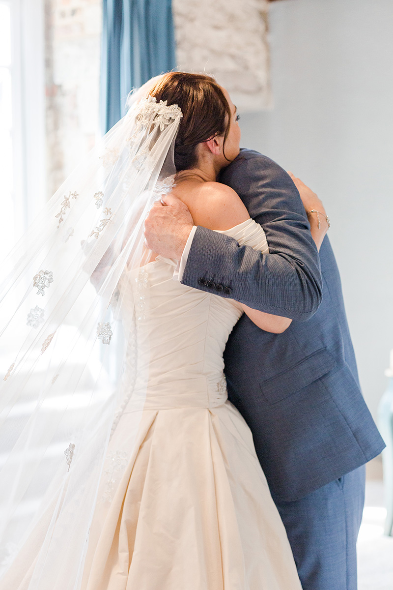 father of bride hugs bride