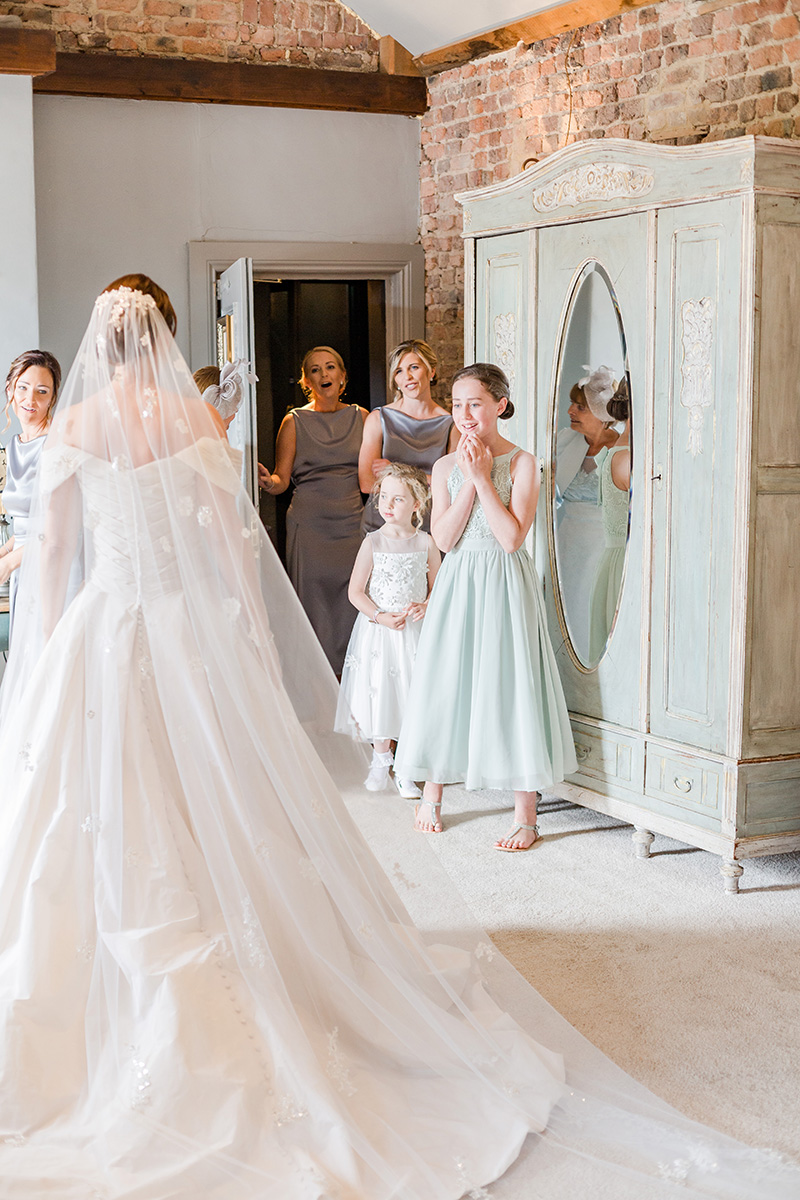 bridesmaids see bride for the first time in gown