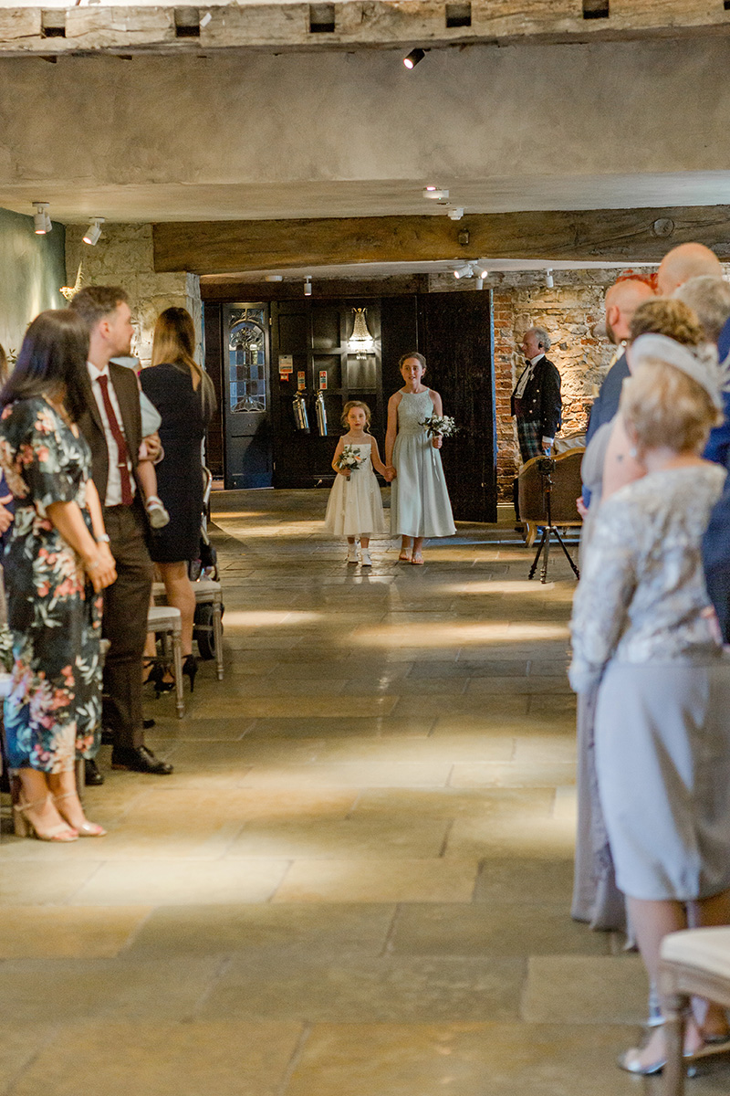 bridesmaid and flower girl walk down aisle