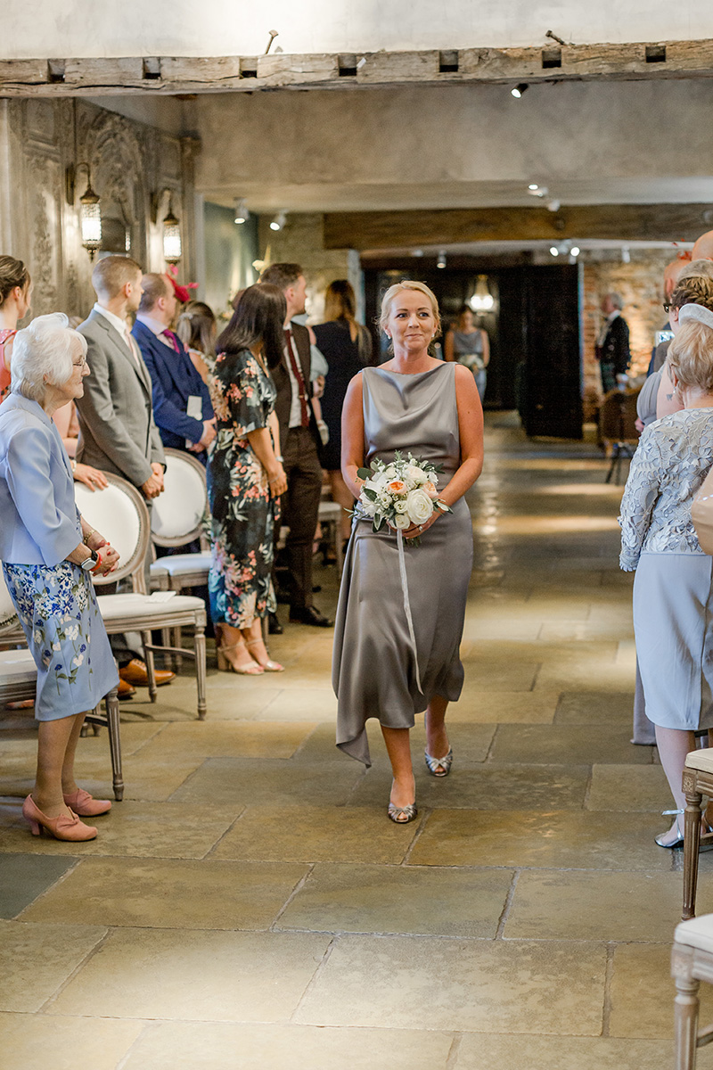 groom watches bridesmaid walking down aisle