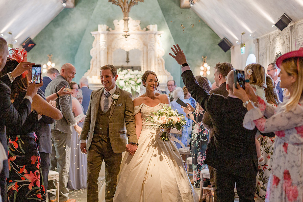 bride and groom under confetti