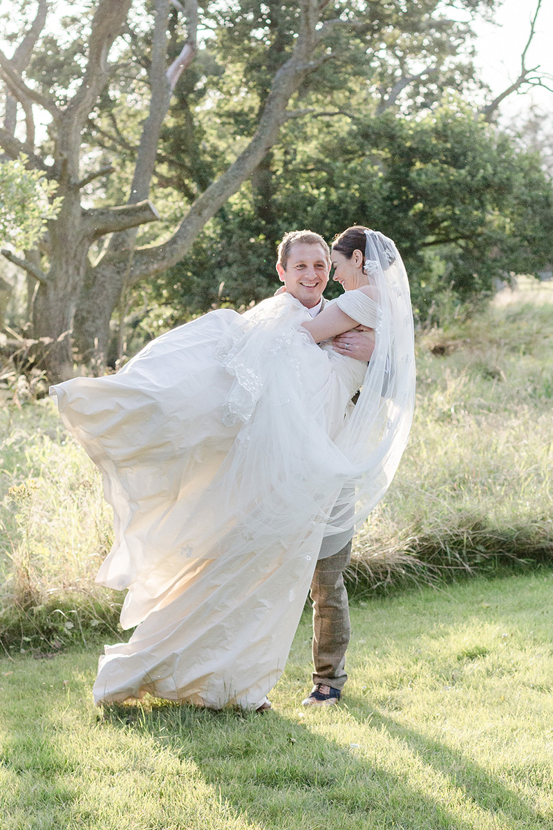 groom lifting bride with dress flowing