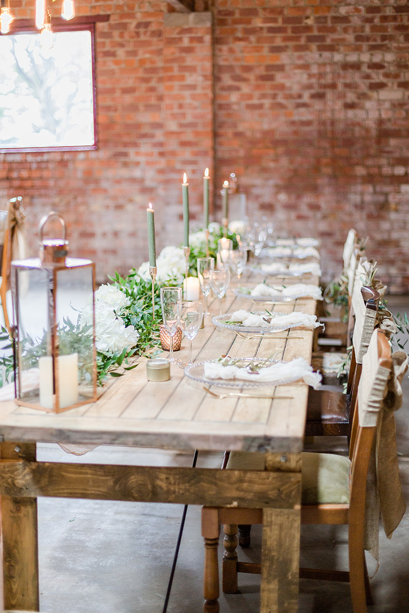 long top table at wedding with candles and place settings