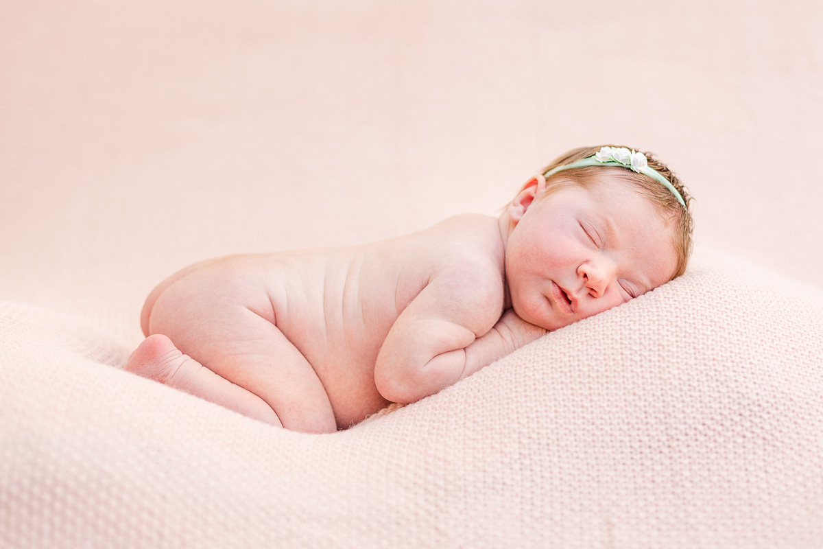 baby girl asleep on front with pink background