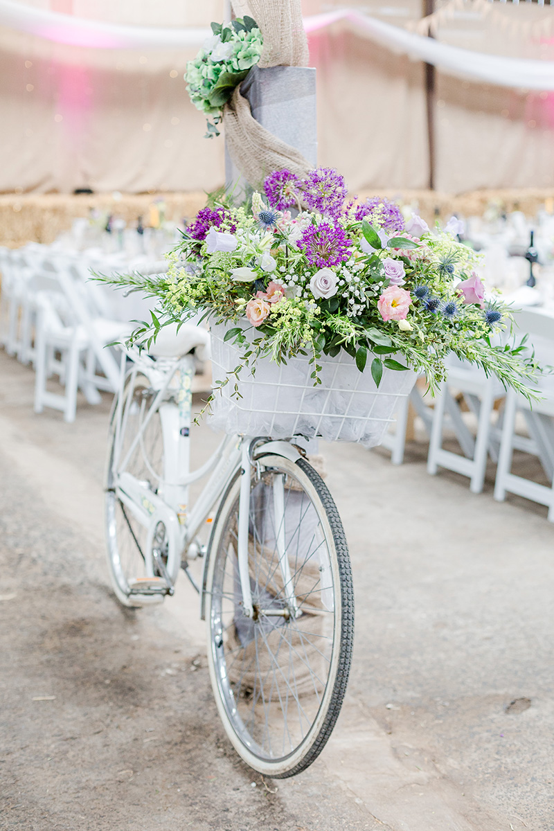 white vintage bicycle with large flour arrangment in basket