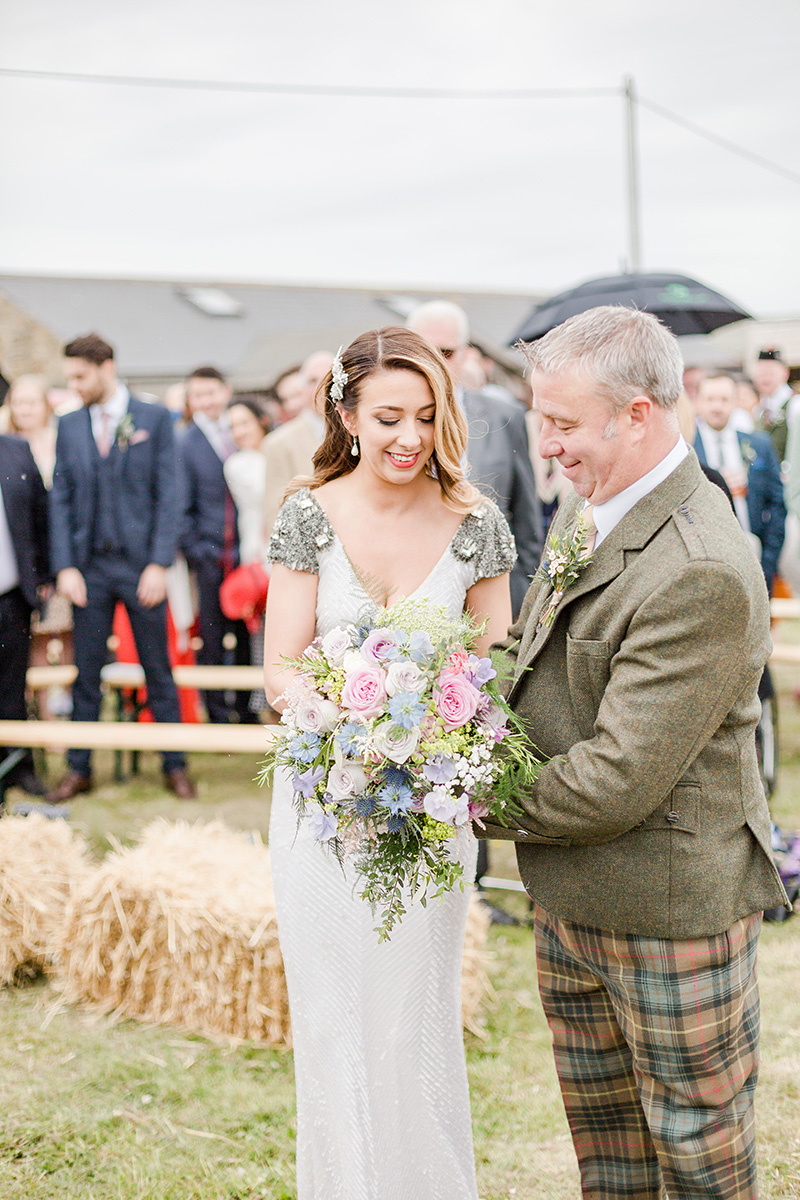 bride handing father of bride her bouquet