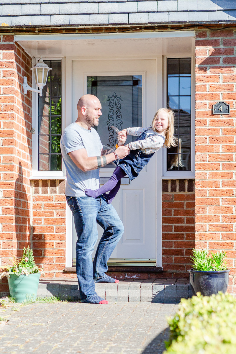 little girl and daddy playing on doorstep