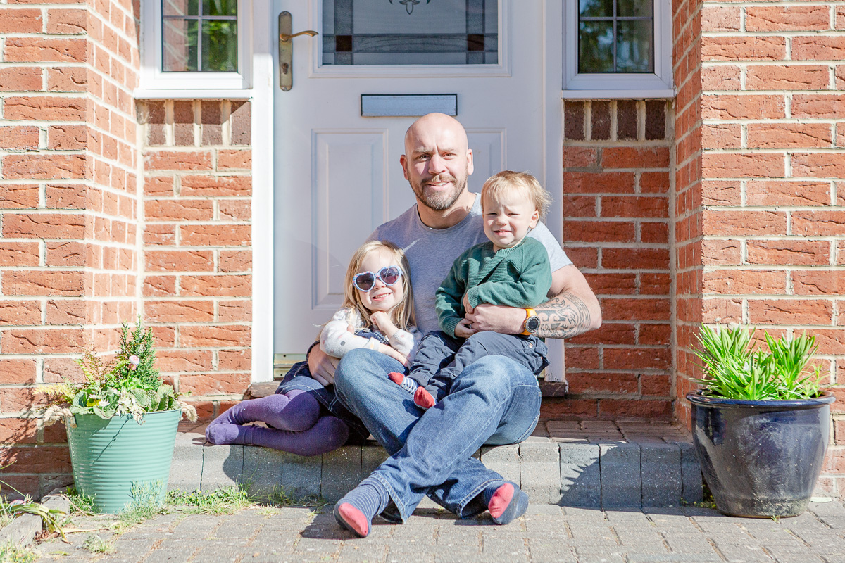 daddy sat on doorstep with daughter and son