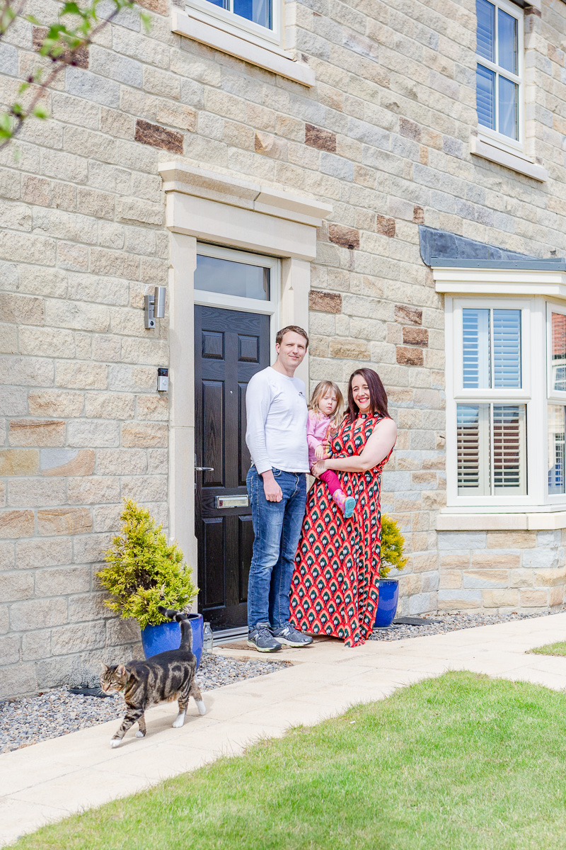 family on doorstep with cat