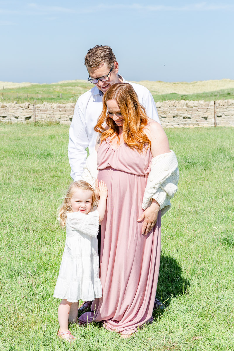 family together rubbing pregnancy bump