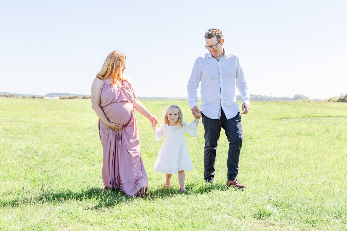 family holding hands in field