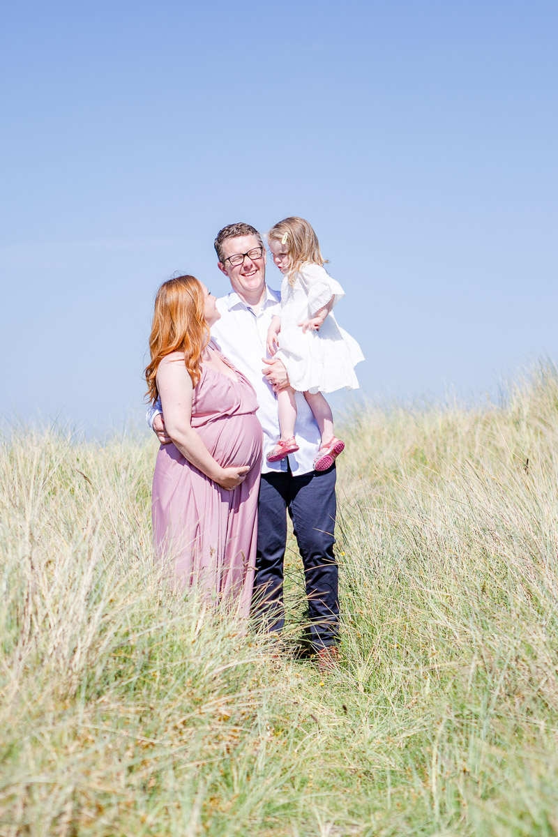 family laughing together in long grass