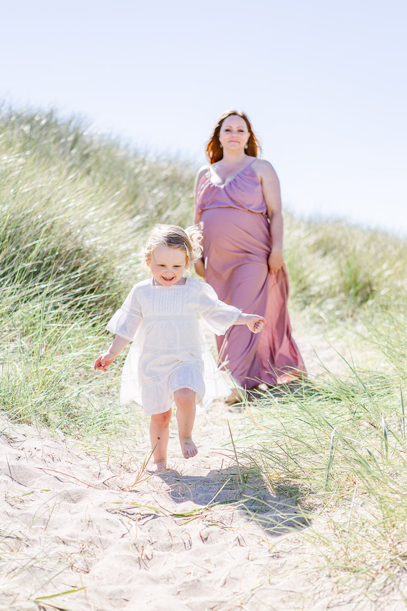 toddler running down sand away from mummy