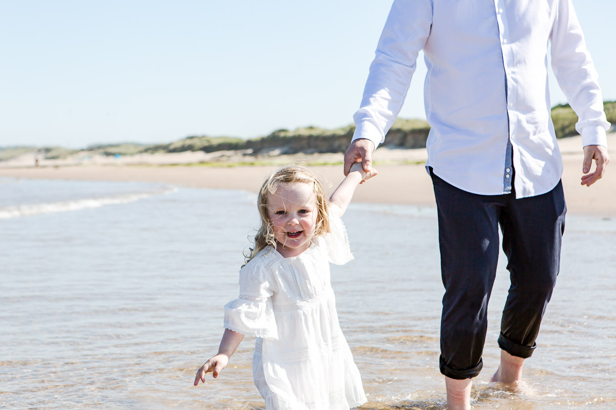 daughter pulling daddy through the waves