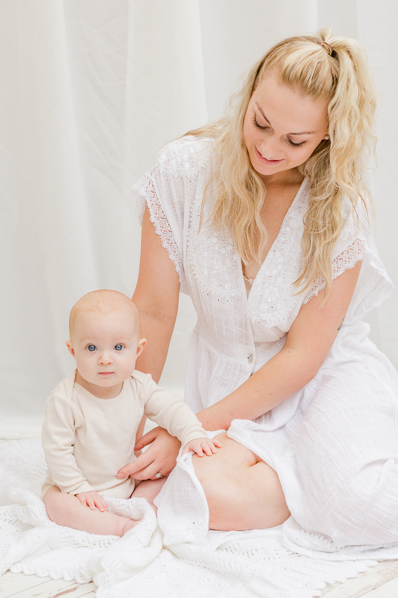 mummy and me photography session daughter sat on fur and mummy smiling