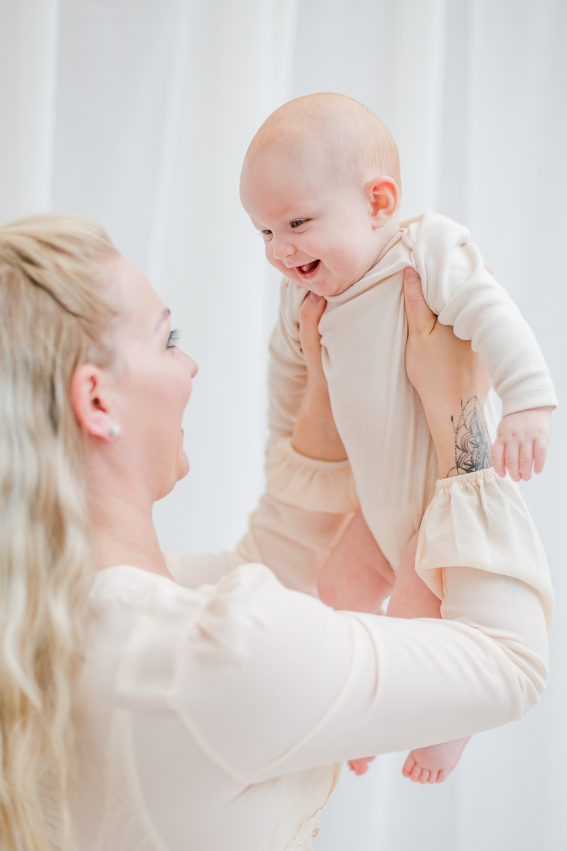 baby and me photography session mummy holding daughter up in the air