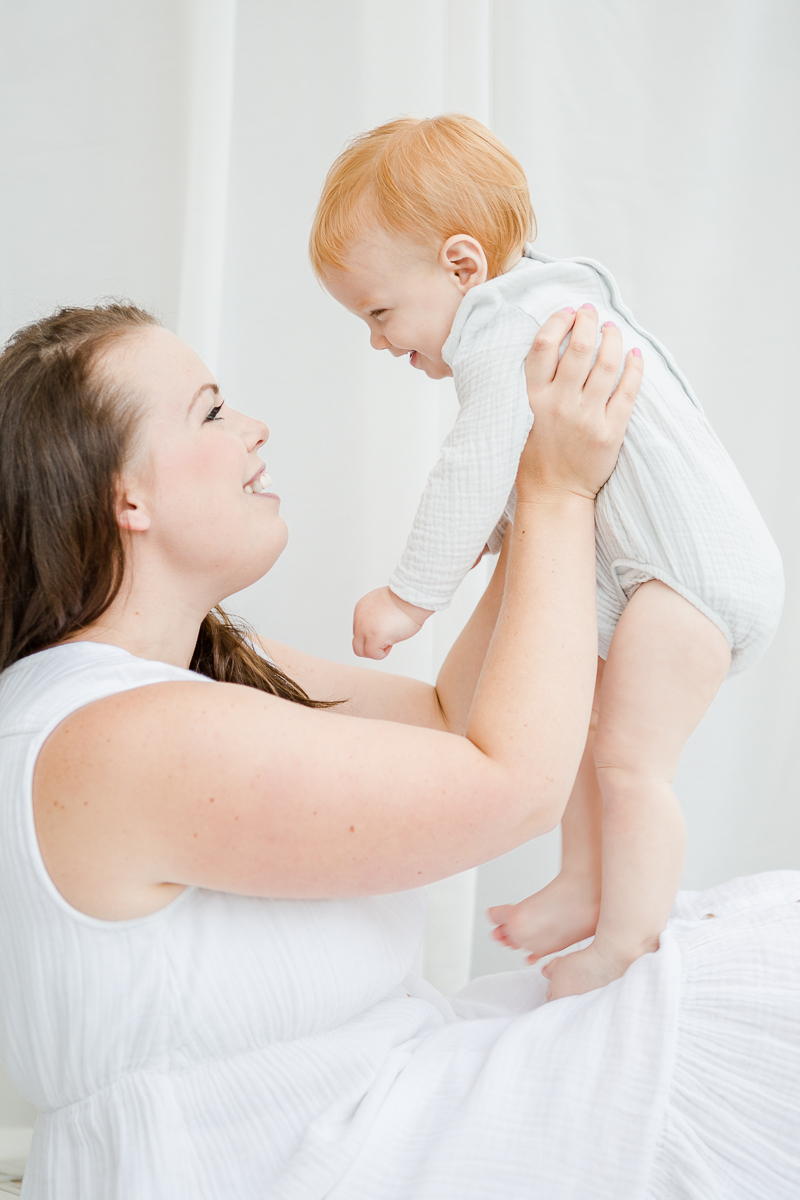 mummy lifting little girl up and smiling at each other