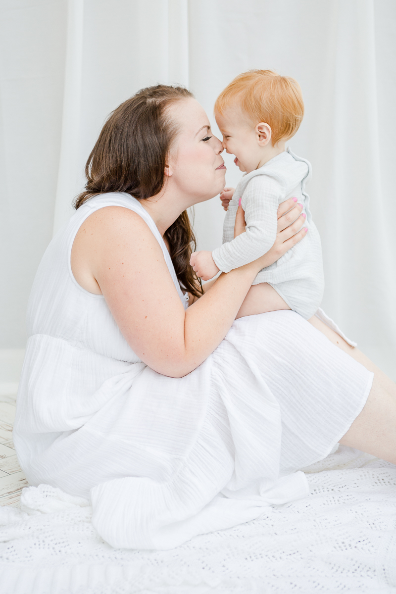 little girl sat on mummy's knee rubbing noses