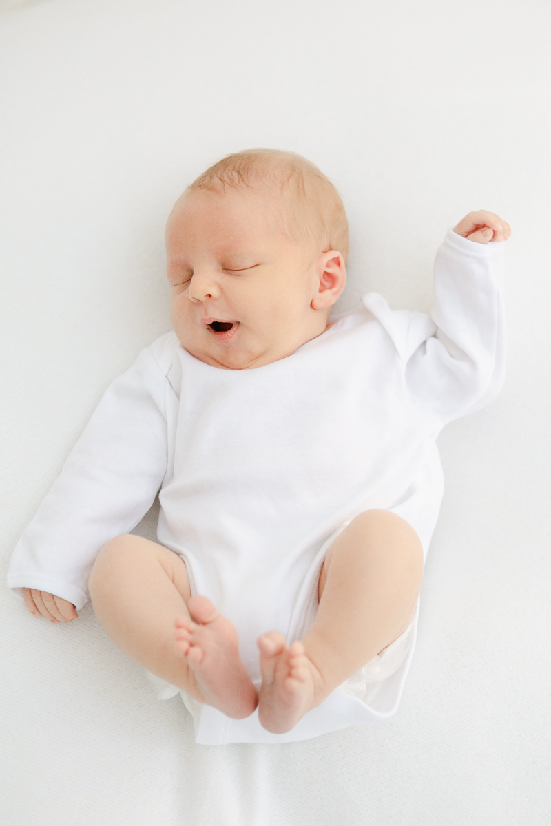 baby in white vest stretching