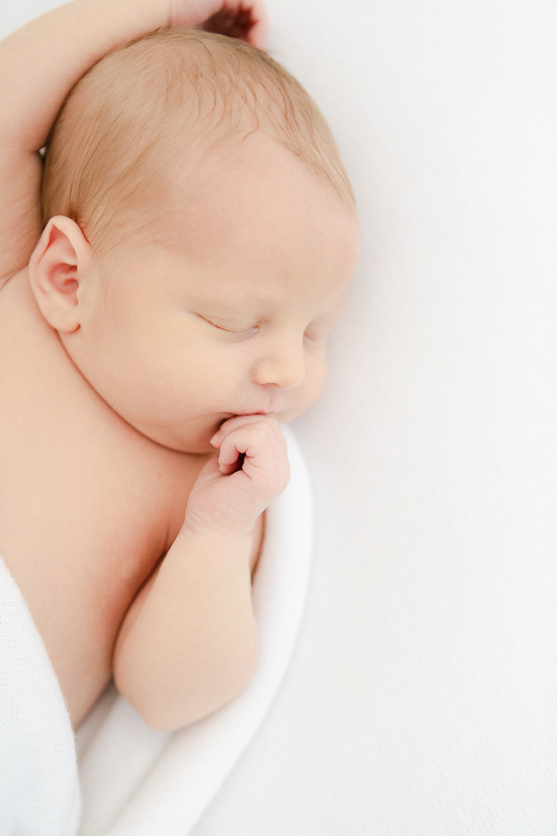 newborn baby asleep with and in mouth