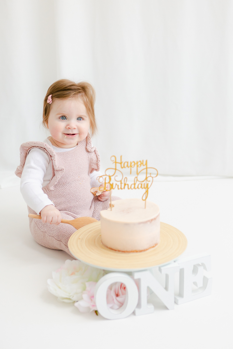 little girl in studio with cake smash cake