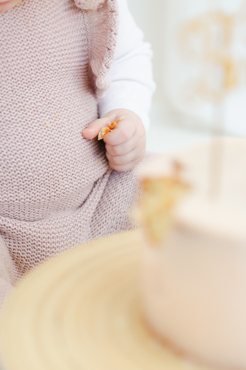 close up of little girls hand holding cake