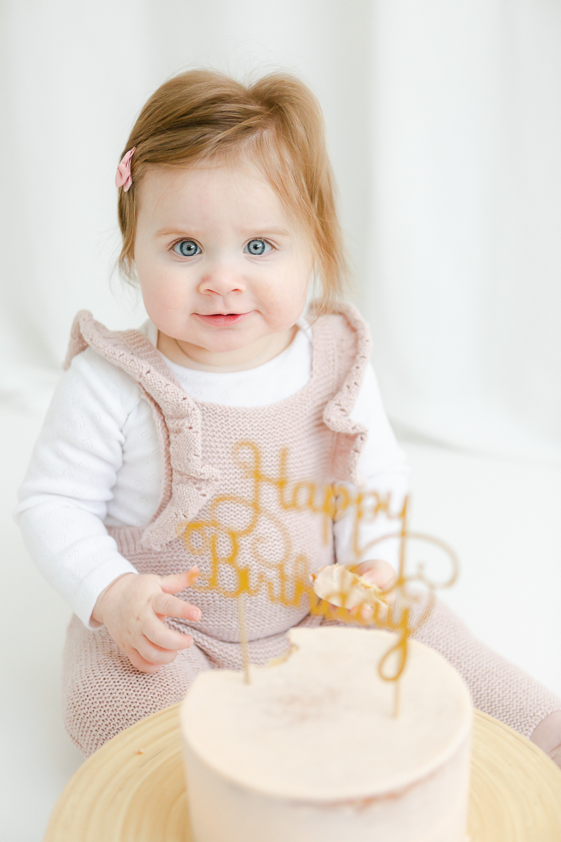 little girl in pink with happy birthday cake